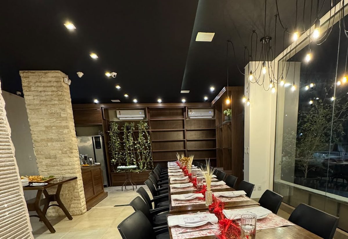 Mesa longa montada para um evento no salão